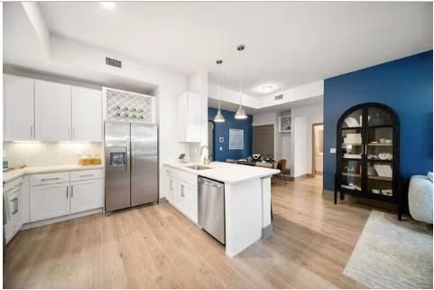 Apartment kitchen with white cabinets, a breakfast island and stainless steel appliances
