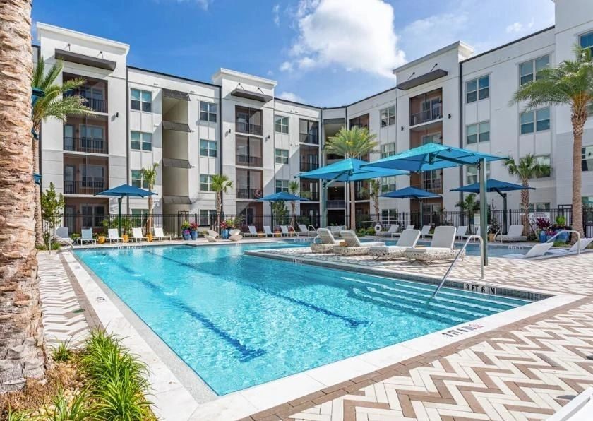 Outdoor swimming pool and sun loungers beside the student apartment building
