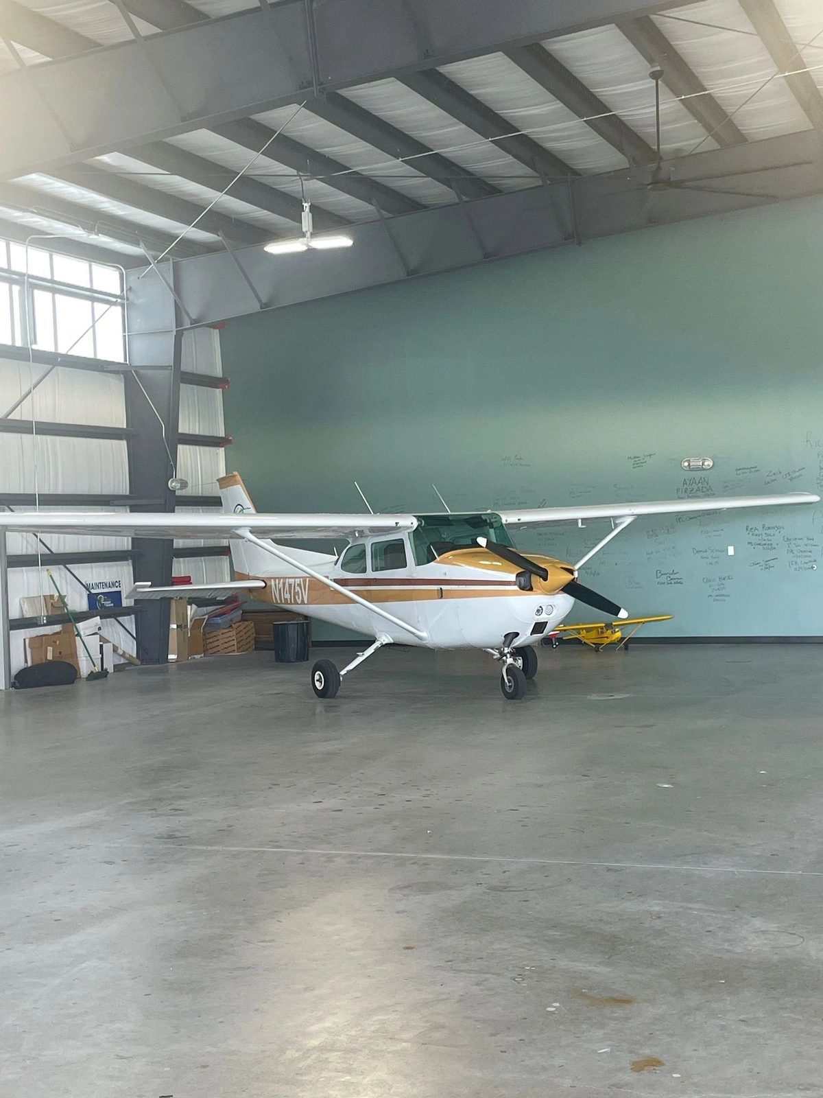 A single-engine Cessna parked inside an open hangar
