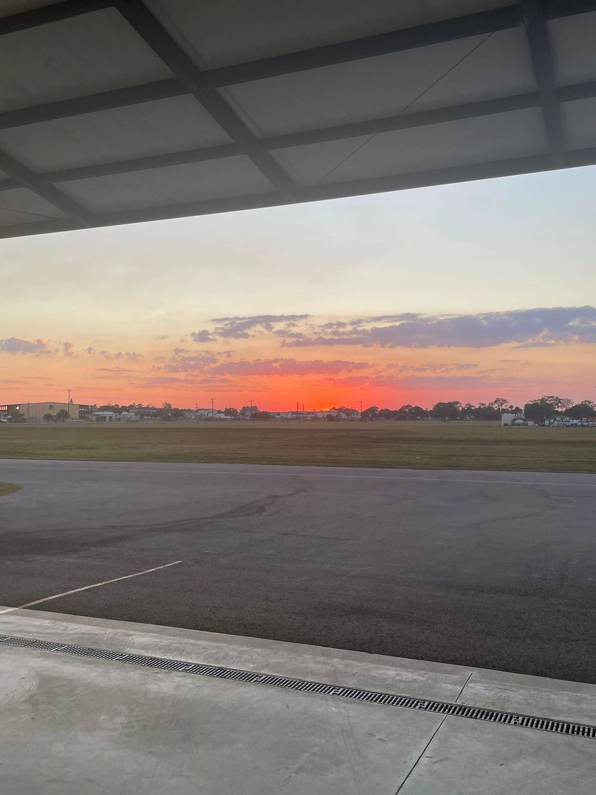 Sunset over the runway, seen from inside the hangar